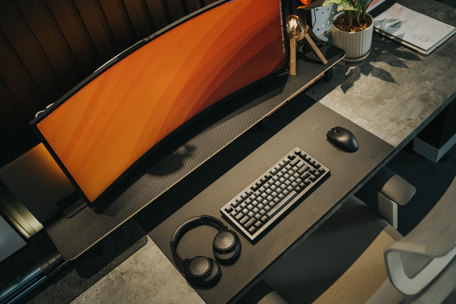 Escritorio gaming moderno y resistente con monitor curvo y accesorios organizados